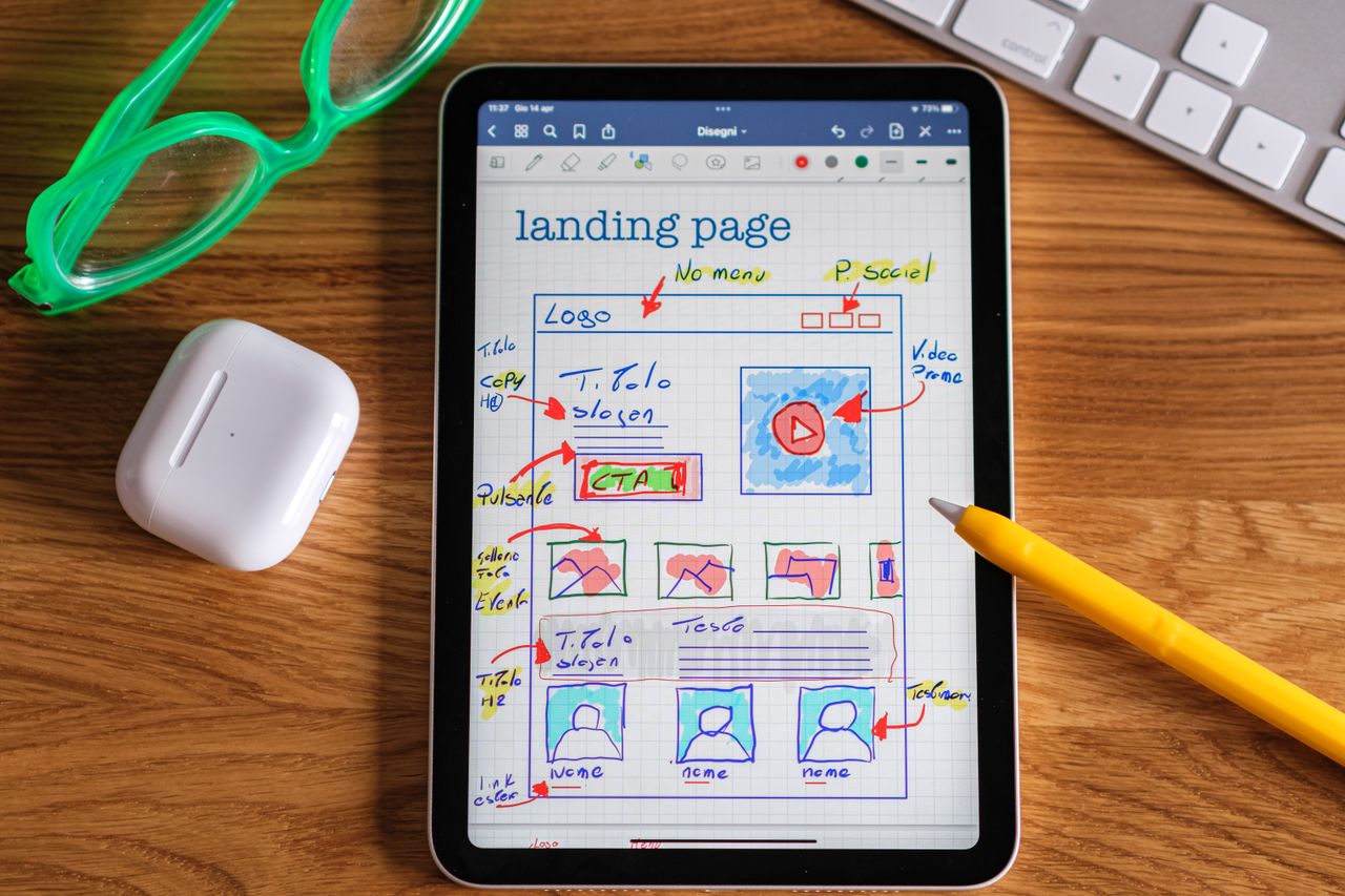 The Art of Drawing Readers In: Your attractive post title goes here Close-up of tablet showing a hand-drawn landing page design, ideal for web development concepts.